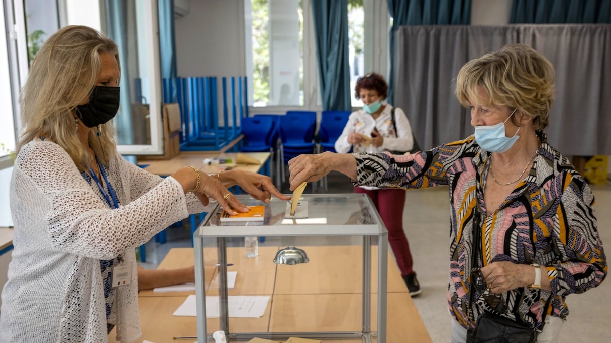 Une femme dépose son bulletin de vote pour le premier tour des élections législatives françaises dans un bureau de vote à Rabat, le 5 juin 2022.
