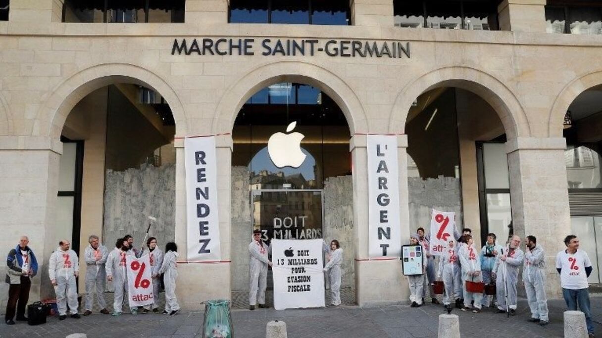 Les militants d'Attac devant la boutique peinte par leur soin à Paris. 
