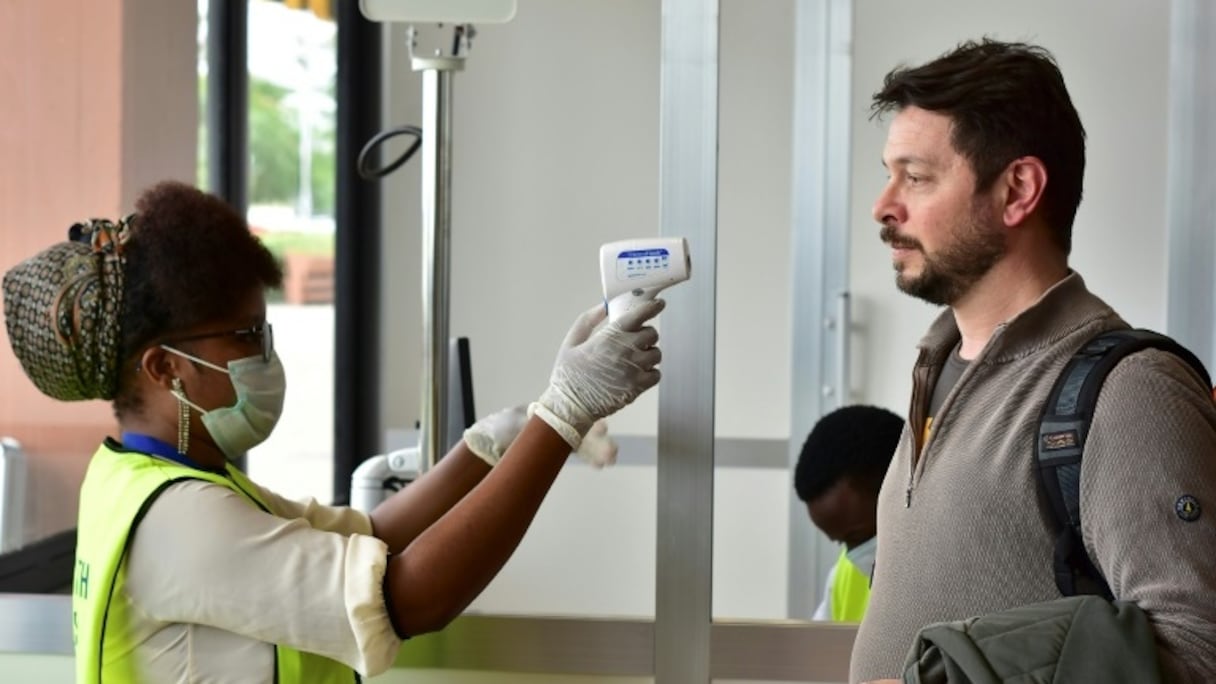 La température d'un passager est contrôlée à l'aéroport international du Kilimanjaro dans le nord de la Tanzanie, le 28 février 2020.
