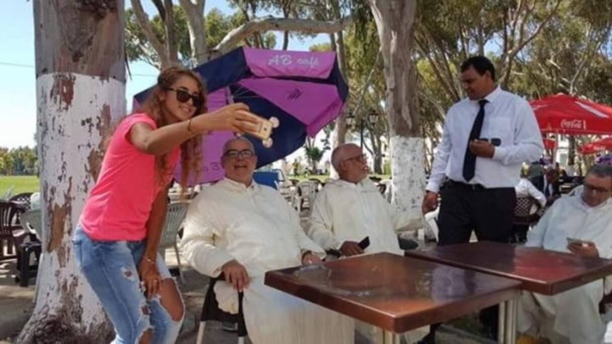 Une jeune prenant un selfie avec Benkirane, en présence de Yatim et Tahar Lakhlaj (debout).
