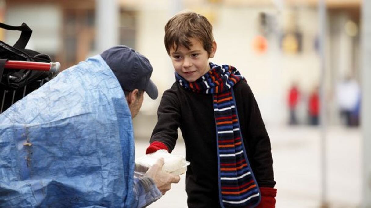 Magnifique geste d'un enfant offrant son sandwich à un sans-abri. 

