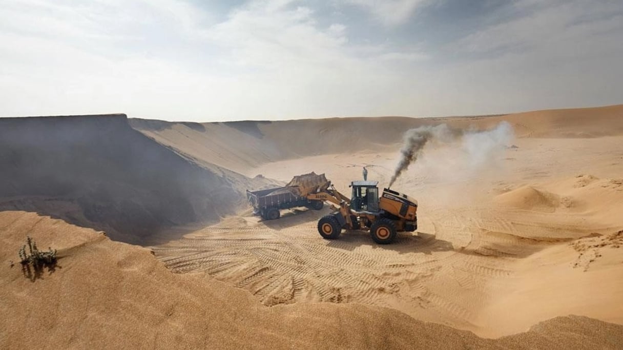 Des engins extraient du sable dans une carrière.
