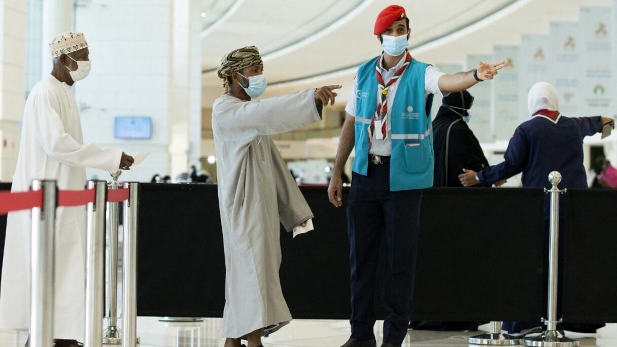 Un volontaire aide des hommes pendant la deuxième phase du plan national de vaccination contre le Covid-19 à l'Oman Convention & Exhibition Centre, dans la capitale, Mascate, le 23 juin 2021.
