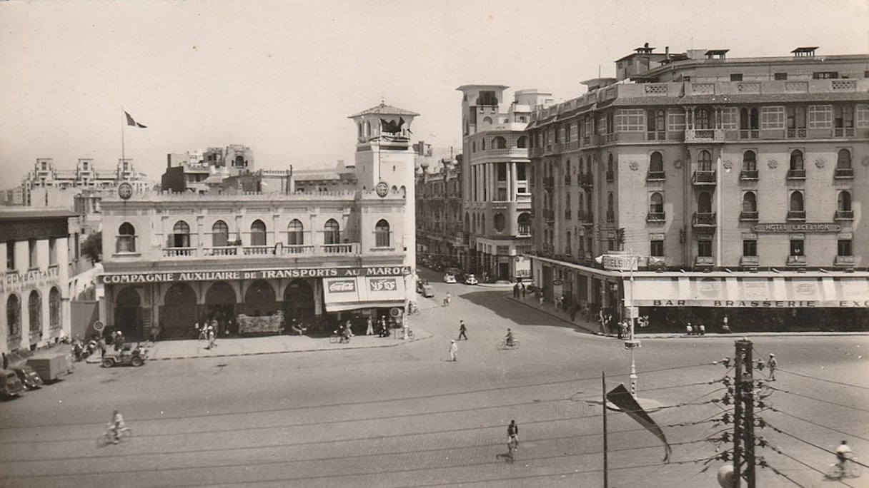 Près de 38 ans après l'instauration du protectorat français sur la première moitié nord du Maroc, le centre-ville de Casablanca, initié par le maréchal Lyautey: la place de France, l'hôtel Excelsior, l'entrée de la rue de l'Horloge, en 1950.
