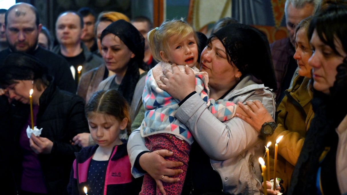 Anna (à droite) et Sofia (à gauche), filles du militaire ukrainien Ruslan Borovyk, tué au combat avec les troupes russes, lui rendent hommage lors de funérailles à la cathédrale Saint-Michel de Kiev, le 4 mai 2022.
