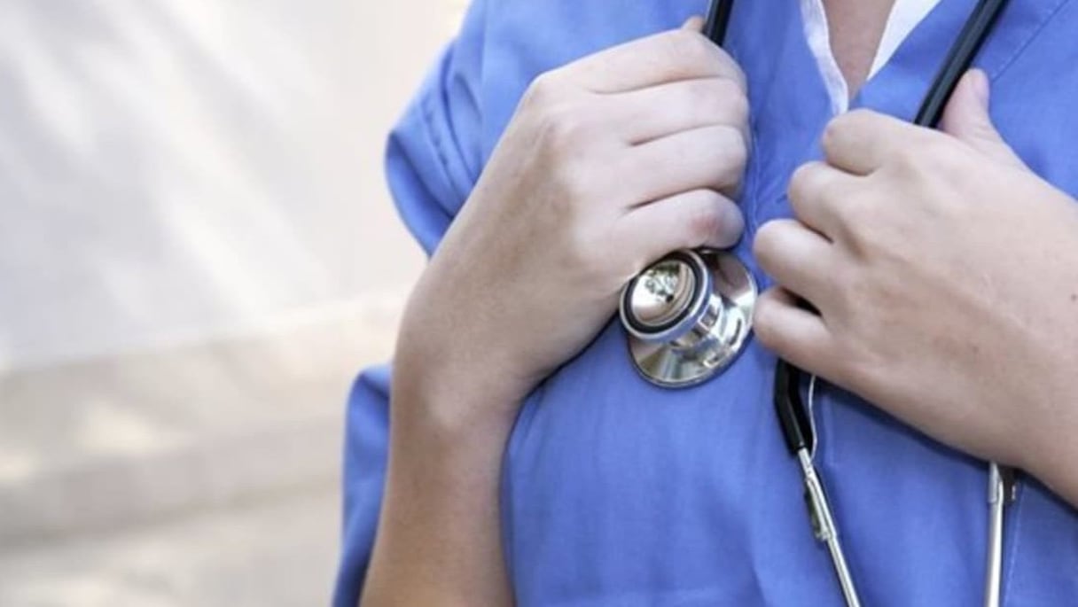 Docteur en médecine, stéthoscope autour du cou. 
