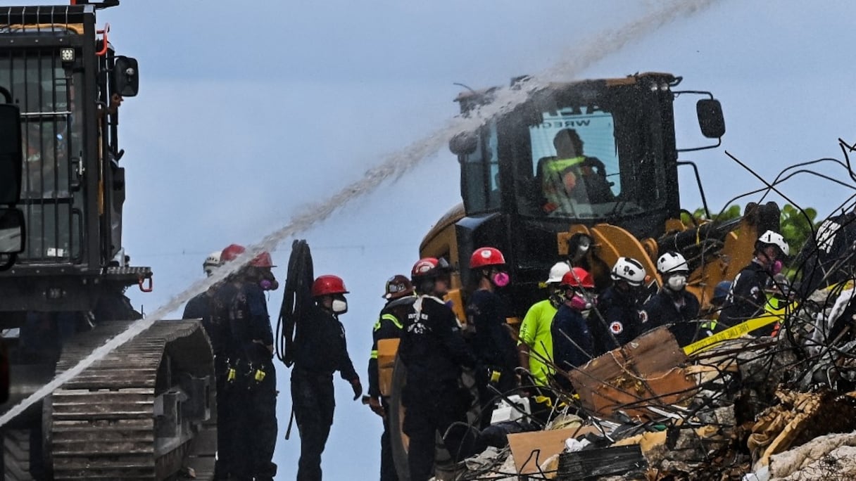 Des secouristes continuent de fouiller les décombres sur le site d'un immeuble effondré à Surfside, en Floride, au nord de Miami Beach, le 26 juin 2021. 
