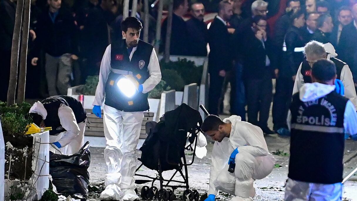 Des agents de la police scientifique enquêtent sur les lieux alors que d'autres policiers sécurisent la zone après qu'une forte explosion d'origine inconnue a secoué la rue commerçante animée d'Istiklal, au centre d'Istanbul, en Turquie, le 13 novembre 2022.
