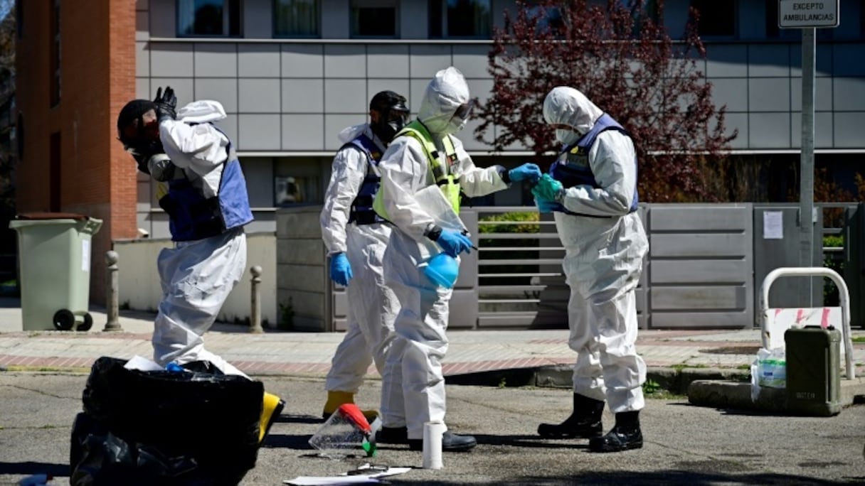 Des membres de l'unité d'urgence militaire se préparent à désinfecter une résidence pour personnes âgées, le 28 mars 2020 à Madrid.
