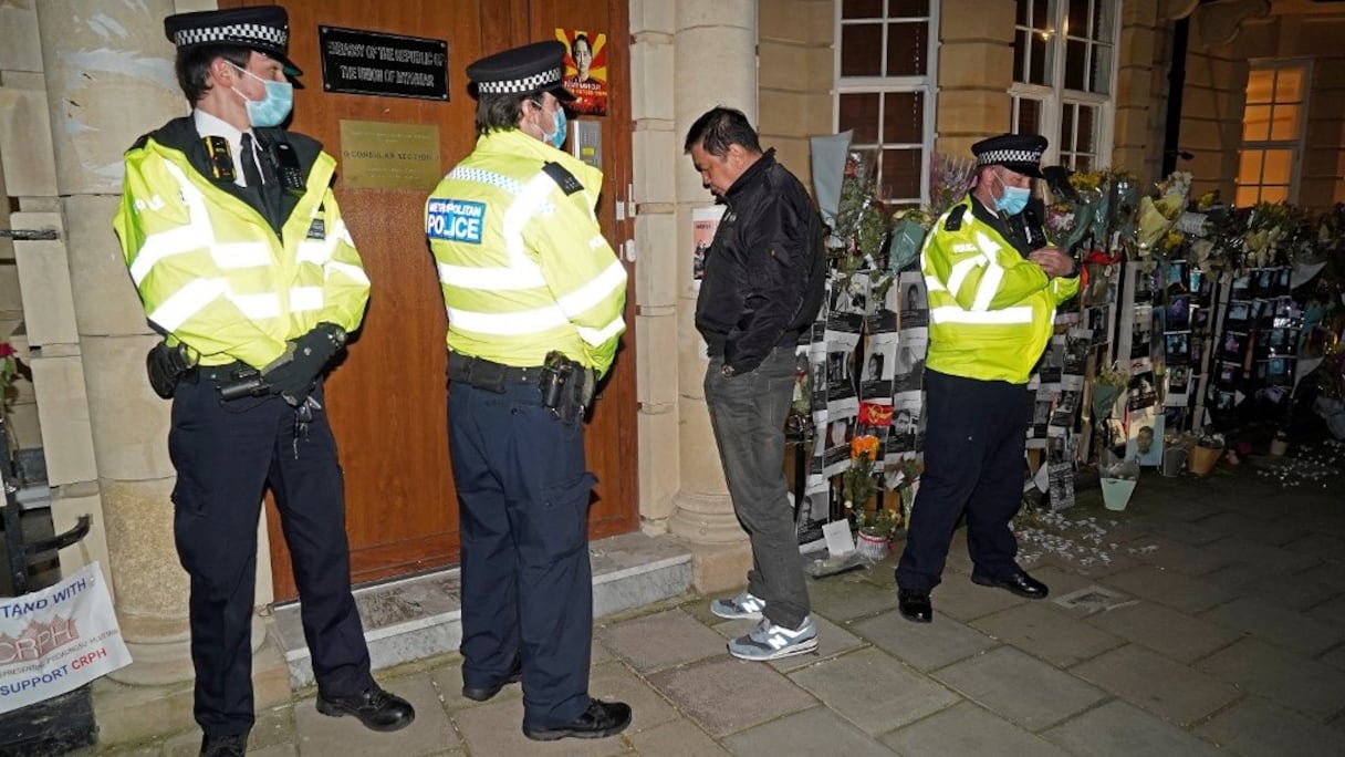 L'ambassadeur de Birmanie au Royaume-Uni, Kyaw Zwar Minn, attend en vain une réponse à l'interphone, alors que des policiers sont en faction devant cette représentation diplomatique à Londres, le 7 avril 2021.
