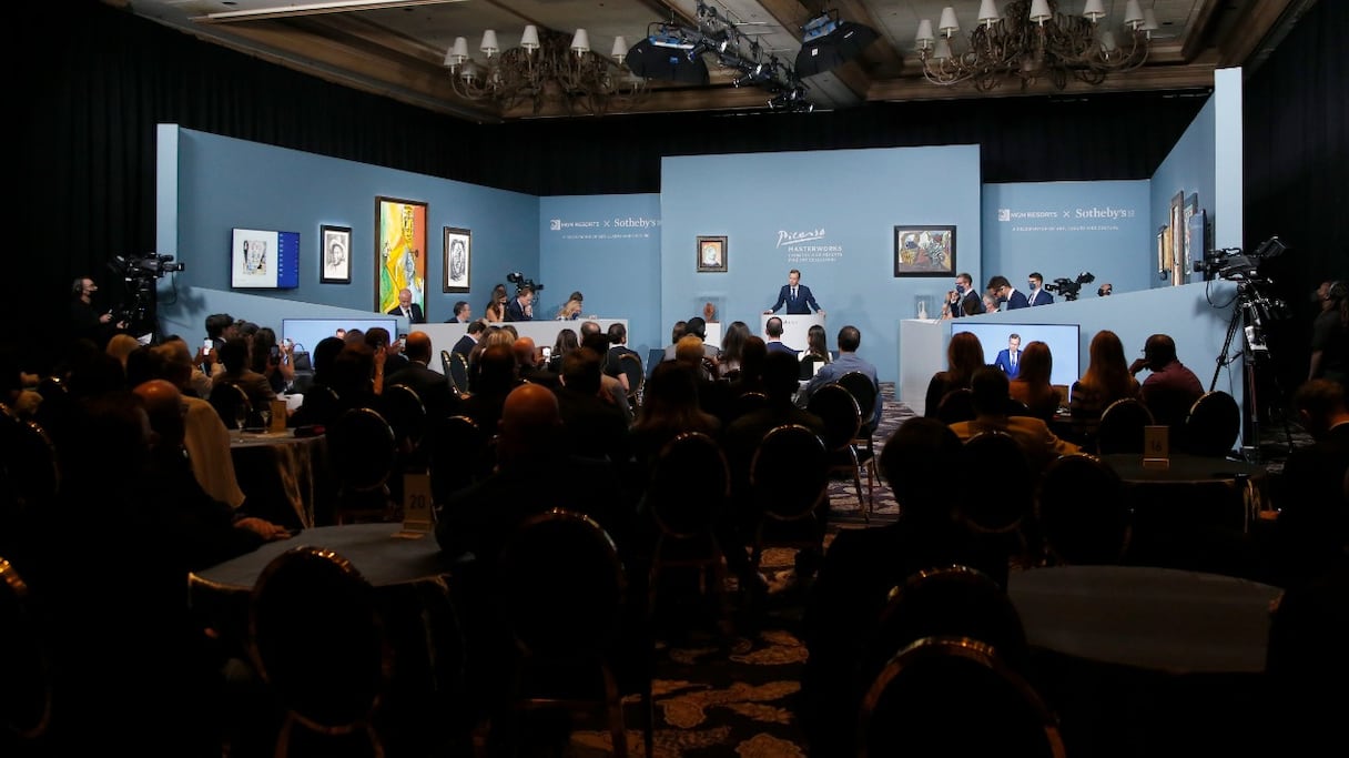 Le commissaire-priseur Oliver Barker interagit avec le public et les employés de Sotheby's qui prennent des offres au téléphone lors de la vente aux enchères "Picasso: Masterworks From The MGM Resorts Fine Art Collection" au Bellagio Resort & Casino, le 23 octobre 2021, à Las Vegas.

