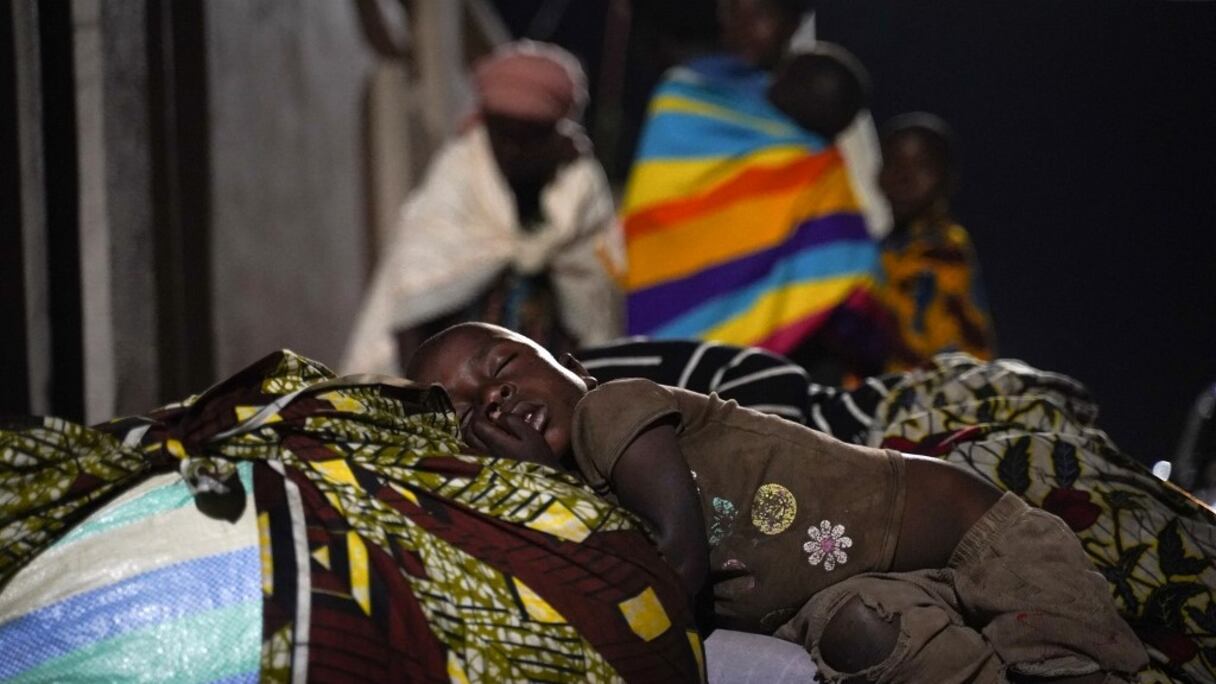 Un enfant dort au milieu de Congolais ayant fui Goma, en République démocratique du Congo (RDC), après l'éruption du volcan Nyiragongo près de la frontière à Gisenyi, au Rwanda, le 23 mai 2021. 
