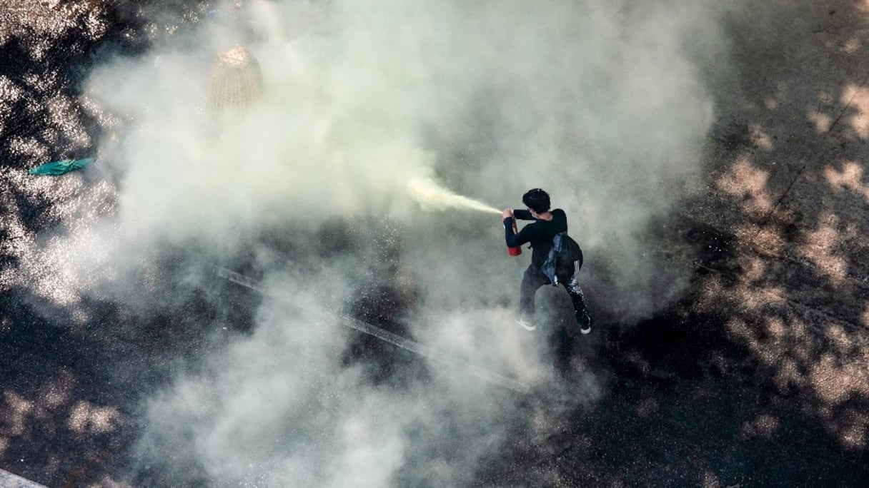 Un manifestant utilise un extincteur alors que les forces de sécurité répriment les manifestations contre le coup d'Etat militaire, à Rangoun, le 28 février 2021.
