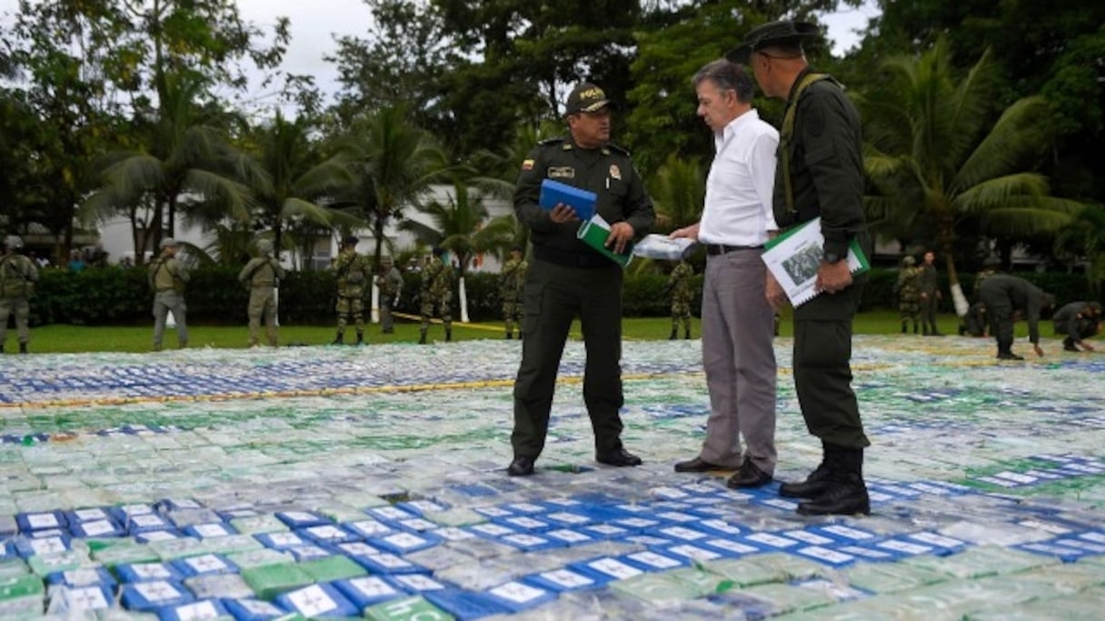 Juan Manuel Santos converse avec un membre d'une unité antinarcotiques alors qu'il marche sur 12 tonnes de cocaïne.
