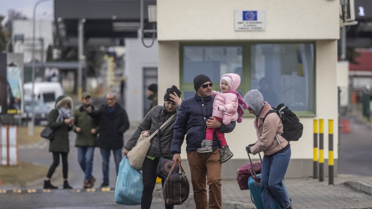 Des réfugiés se rassemblent pour prendre un bus du poste frontière de Medyka à Przemysl, dans l'est de la Pologne, le 28 février 2022.
