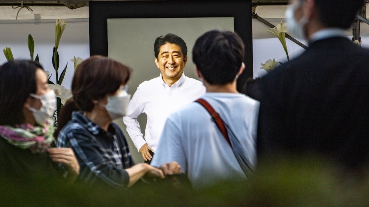 Des personnes offrent des fleurs en hommage à Shinzo Abe, au temple Zojoji à Tokyo, le 11 juillet 2022. L'ex-Premier ministre japonais a été tué par balle le 8 juillet, un crime extrêmement rare dans l'un des pays les plus sûrs au monde.
