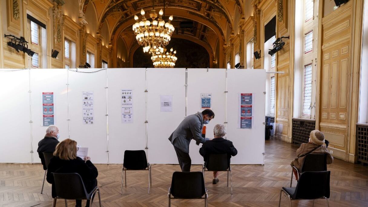 Distanciation sociale de rigueur entre personnes assises dans la salle d'attente d'un centre de vaccination de la mairie du XIIIe arrondissement de Paris, le 18 janvier 2021. 
