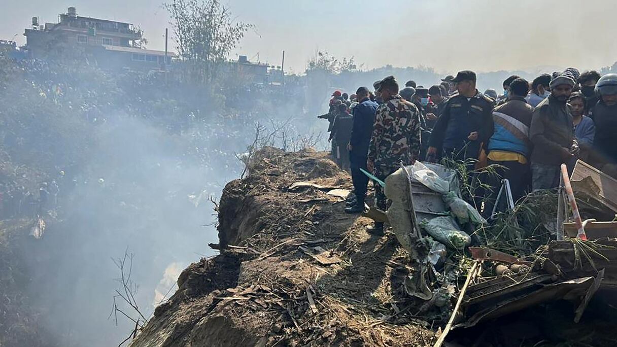 Les secouristes et des curieux sur le site du crash d'avion à Pokhara, le dimanche 15 janvier 2023.
