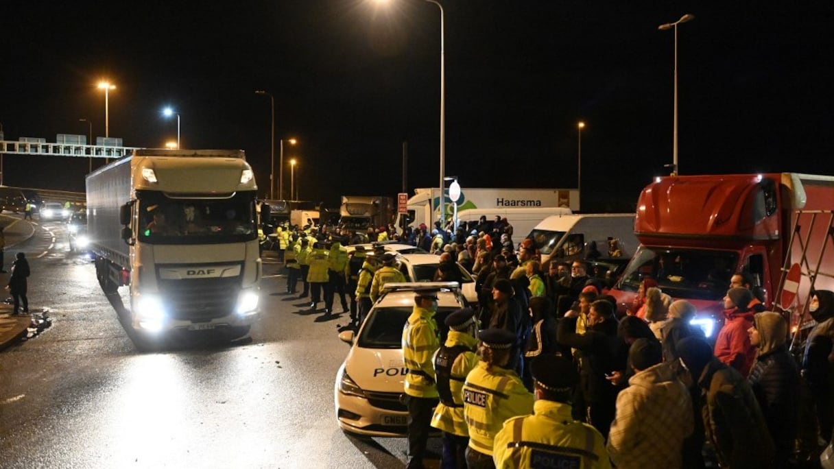 A l'entrée du port de Douvres, des policiers font face à des chauffeurs de camions qui font la queue pour un test du Covid-19, avant leur départ pour Calais, en France, via le tunnel sous la Manche, le 23 décembre 2020. 
