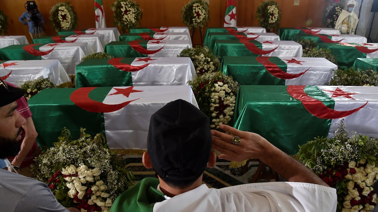 Les cercueils drapés du drapeau algérien contenant les restes de 24 Algériens présumés décapités lors de la conquête coloniale française, présentés au Palais de la culture Moufdi Zakaria à Alger, le 4 juillet 2020, après leur arrivée de France.
