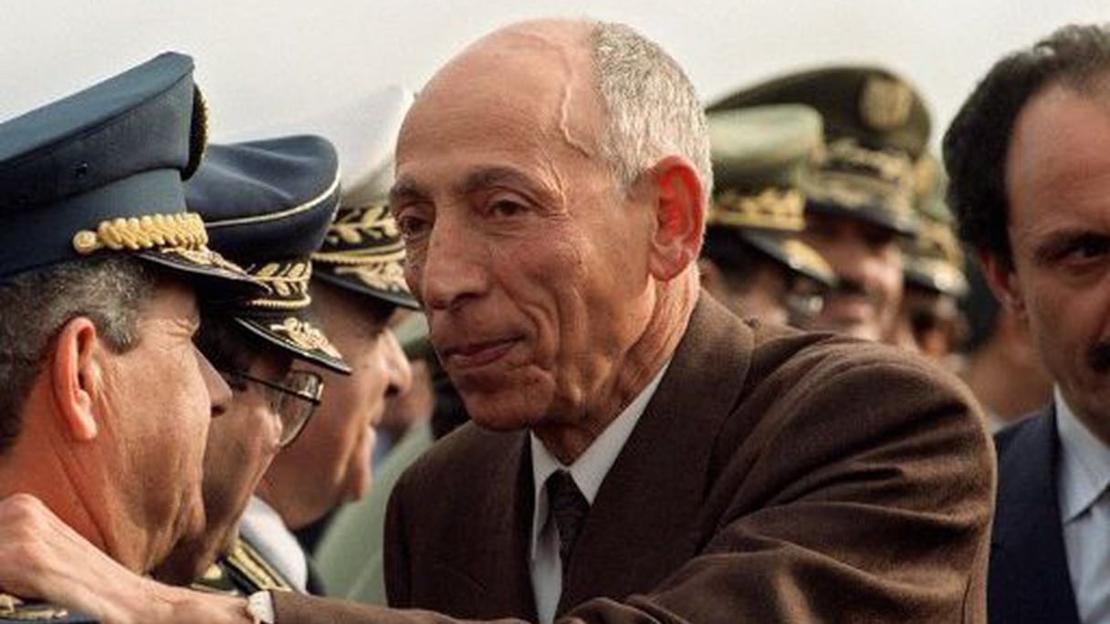 Feu Mohamed Boudiaf salue le chef d'état-major de l'Armée nationale populaire, le général Abdelmalek Gueneizia (à gauche), à l'aéroport d'Alger, le 16 janvier 1992, lors de son retour d'exil. 
