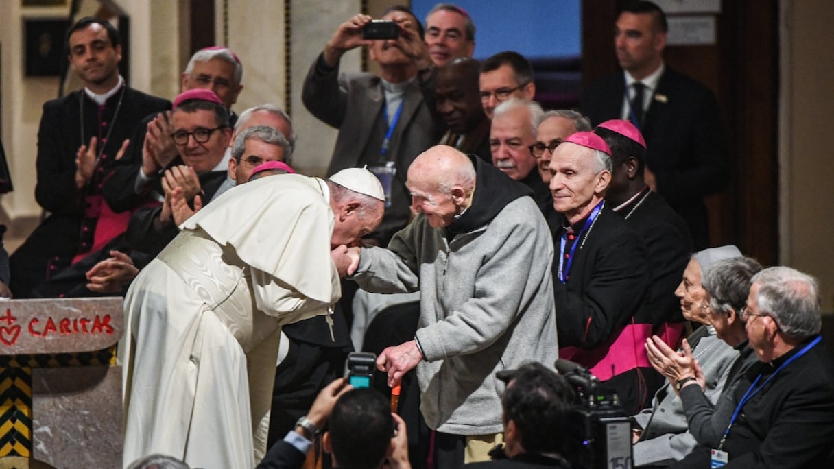 Le pape François se penche pour embrasser la main du moine Frère Jean-Pierre Schumacher, dernier survivant de la prise d'otages des sept moines de Tibhirine pendant la guerre civile algérienne en 1996, à la cathédrale Saint-Pierre de Rabat, le 31 mars 2019. 
