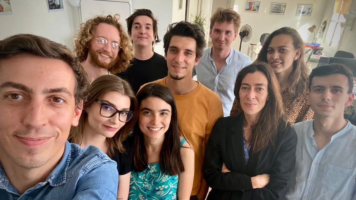 Laurent Richard (devant), tout sourire, pose avec l'équipe de Forbidden Stories, dans un selfie marquant son "joli coup" médiatique. 
