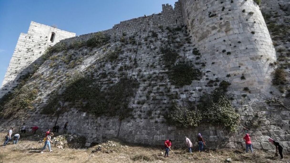 Des dizaines de volontaires débroussaillent le site du château.
