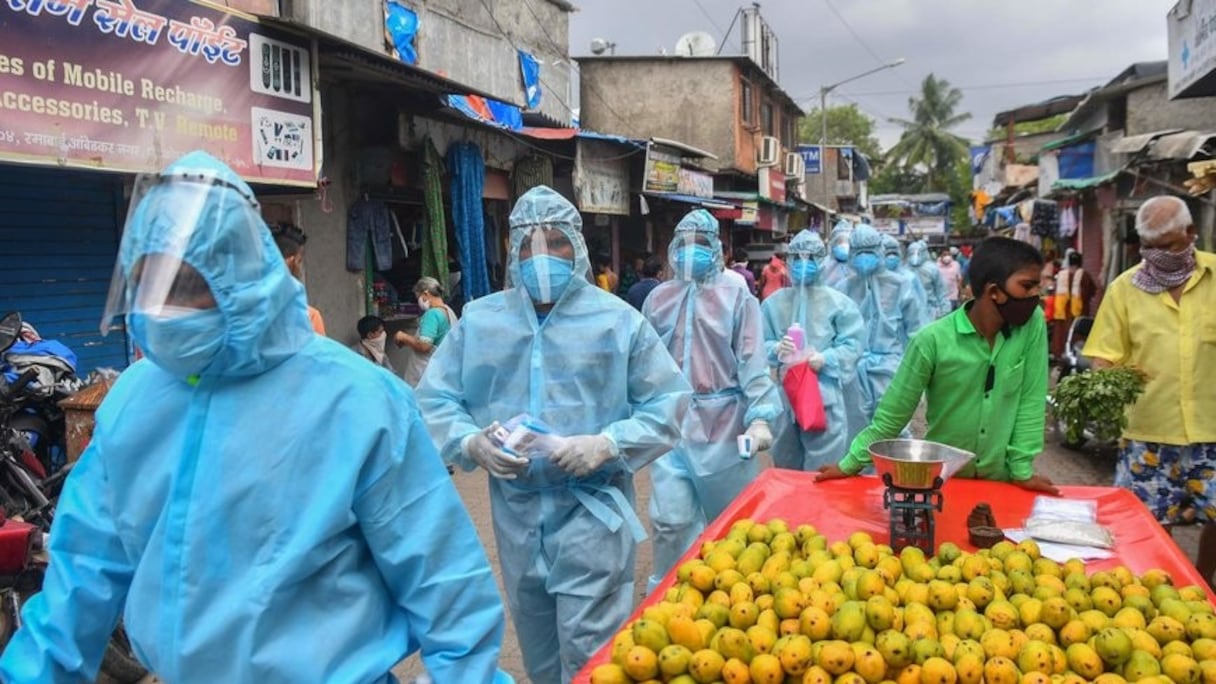 Dans un bidonville de Bombay, le personnel médical fait du porte-à-porte pour des opérations de dépistage.
