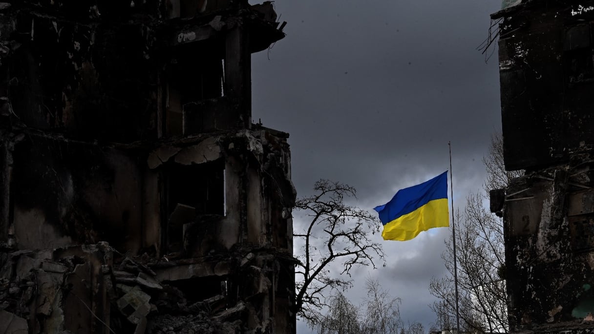 Le drapeau ukrainien flotte entre des bâtiments détruits lors d'un bombardement, dans la ville ukrainienne de Borodianka, dans la région de Kiev, le 17 avril 2022. La Russie a envahi l'Ukraine le 24 février 2022.
