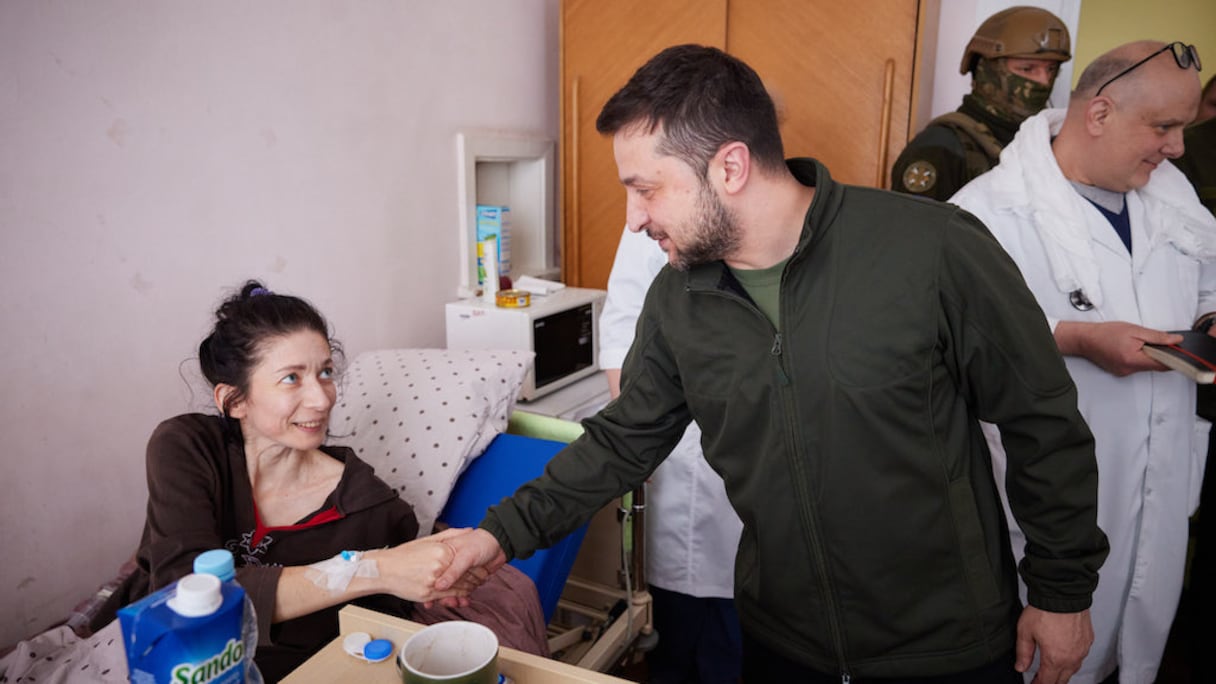 Le président ukrainien Volodymyr Zelensky rend visite à des blessés qui ont fui la ville de Vorzel lors de l'invasion de l'Ukraine par la Russie, dans un hôpital de Kiev, le 17 mars 2022.
