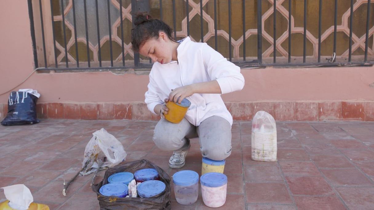 La jeune artiste prépare minutieusement ses couleurs avant de débuter sa performance. 
