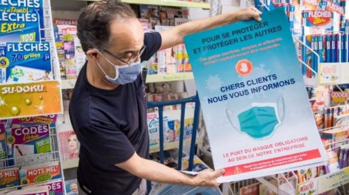 Un vendeur montre une affiche de sensibilisation dans sa librairie de Casablanca, le 28 mai 2020.
