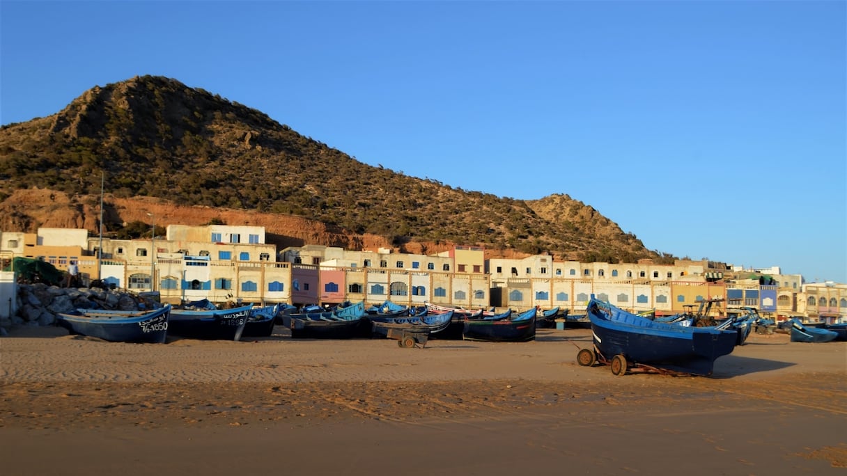 Le village et les barques sur le sable
