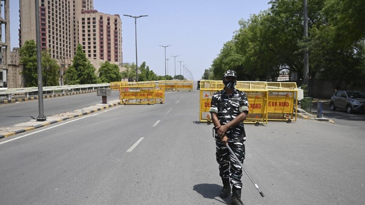 Un agent de police monte la garde à un point de contrôle lors d'un confinement du week-end, imposé par le gouvernement devant l'augmentation des cas de Covid-19, à New Delhi, le 18 avril 2021.
