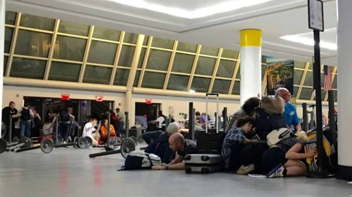 Des passagers se mettent à l'abri sur instructions de la police à l'aéroport JFK de New-York, le 14 août 2016.
