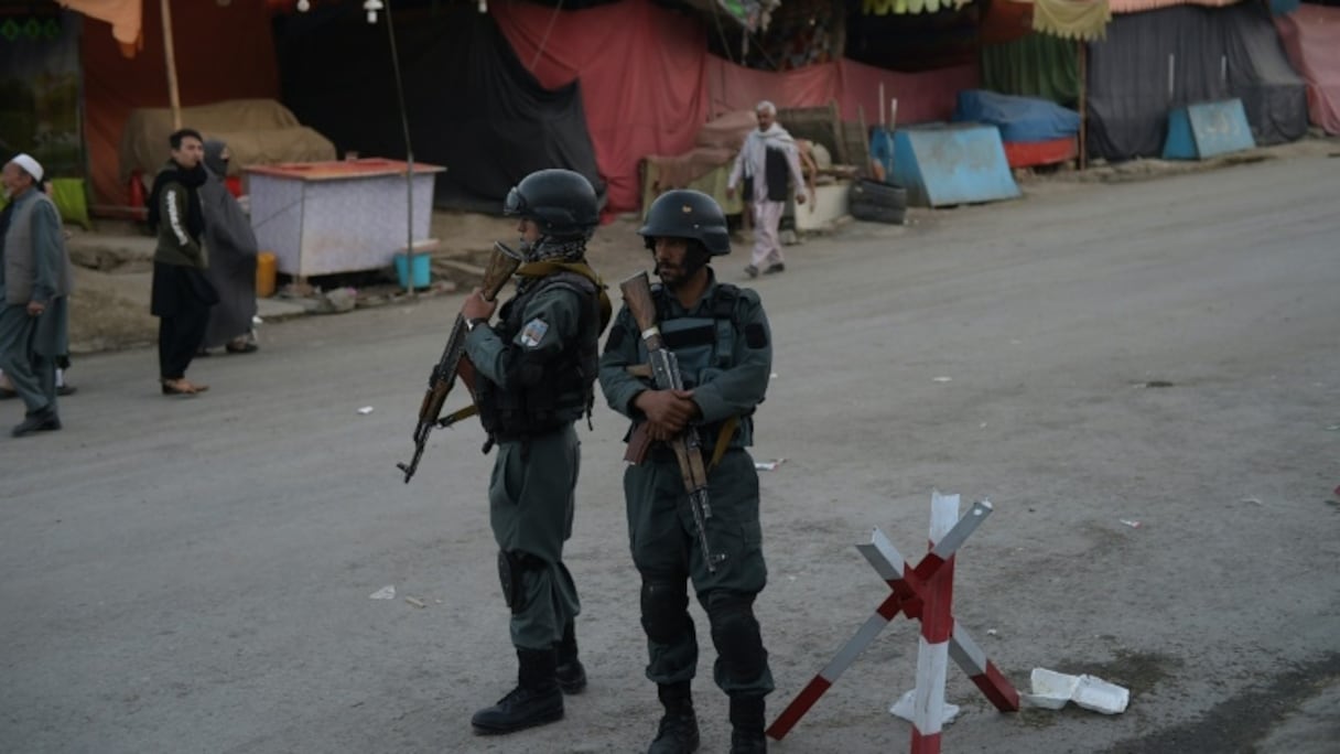 Des policiers surveillent l'entrée principale de la mosquée chiite de Karte Sakhi après une attaque, le 12 octobre 2016 à Kaboul, en Afghanistan.
