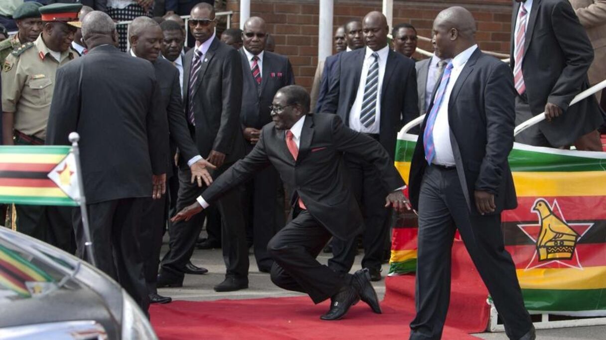 Robert Mugabe tombant sur les genoux en descendant d'un podium après avoir prononcé un discours, le 4 février 2015 à Harare.
