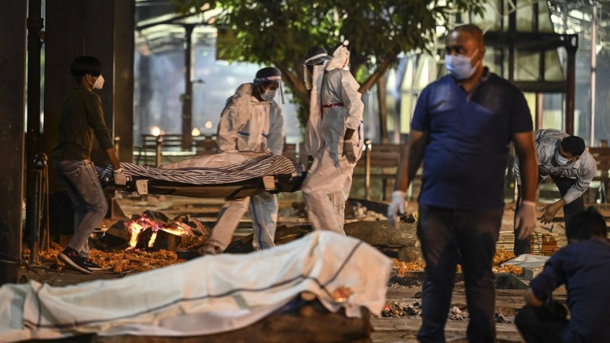 Les proches et le personnel d'une entreprise funéraire portent le corps d'une victime du Covid-19 au crématorium de Nigambodh Ghat, sur les rives de la rivière Yamuna à New Delhi, aux premières heures du 22 avril 2021.
