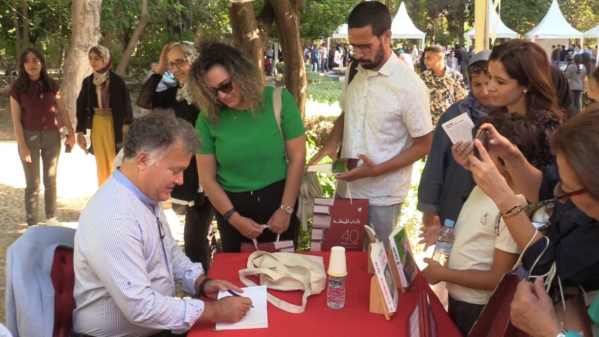 L'écrivain Fouad Laroui dédicace l'un de ses deux derniers ouvrages, au festival Littératures itinérantes, dont l’édition 2022 a eu lieu au parc Jnane Sbil à Fès, le 1er octobre 2022.
