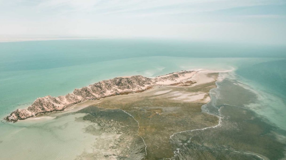 Baie de Dakhla, vue du ciel. La ville se trouve sur une étroite péninsule, à 1.690 km au sud de Rabat, à 30 km du tropique du Cancer, tout comme La Havane, Canton ou Hawaï. Dakhla est l'une des dernières villes du Maroc, avant la frontière avec la Mauritanie. 
