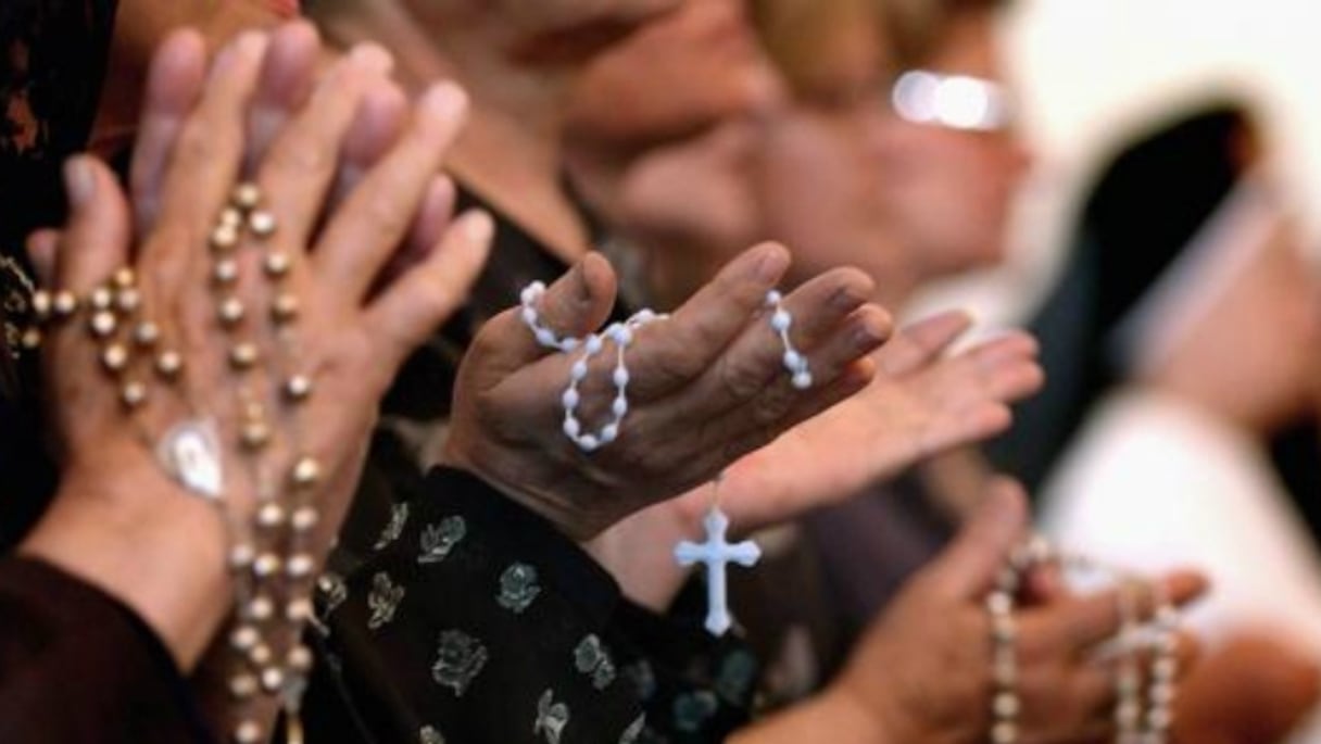 Plusieurs chapelets munis de croix aux mains de femmes chrétiennes en prière. (Photo d'illustration)
