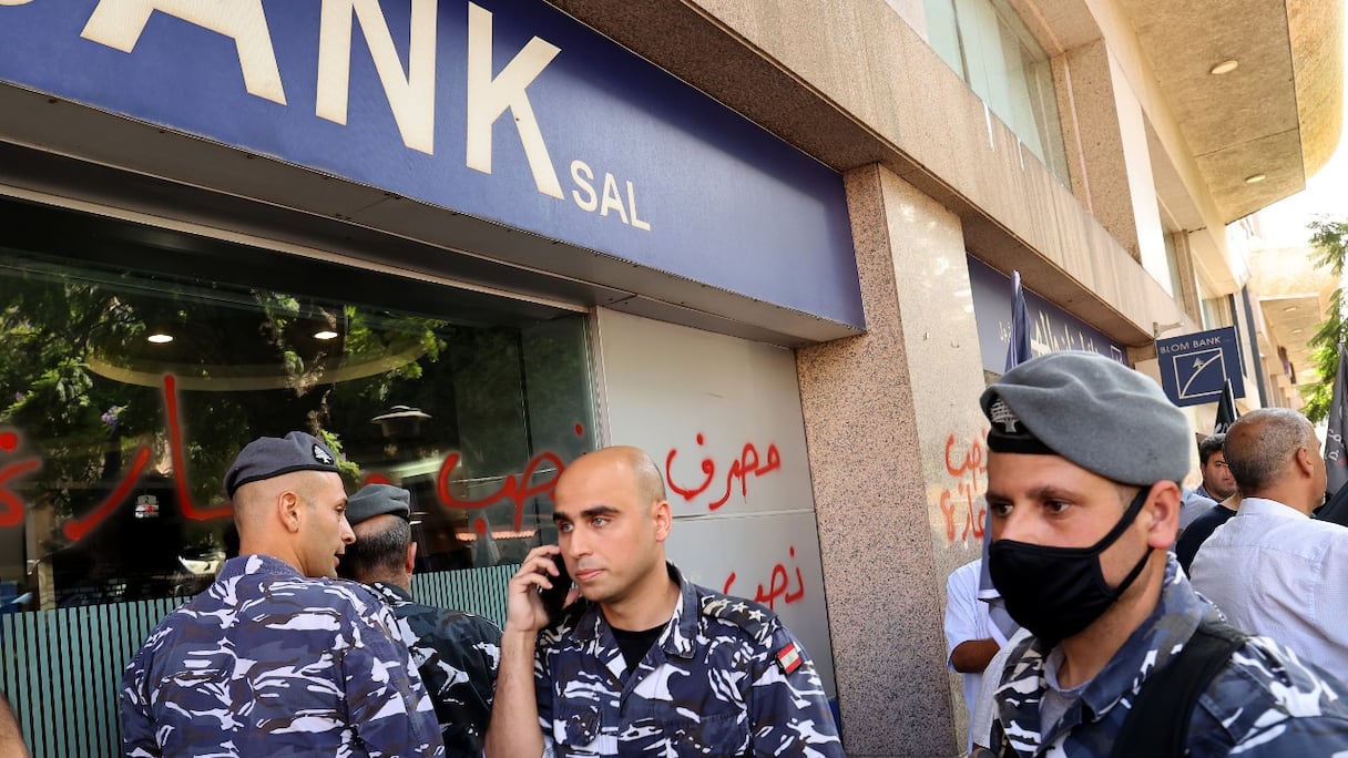 Des membres des forces de sécurité libanaises se rassemblent devant une banque de la capitale Beyrouth, après qu'une femme l'a prise d'assaut pour exiger l'accès aux dépôts de sa sœur pour soi-disant payer ses frais d'hospitalisation, le 14 septembre 2022.
