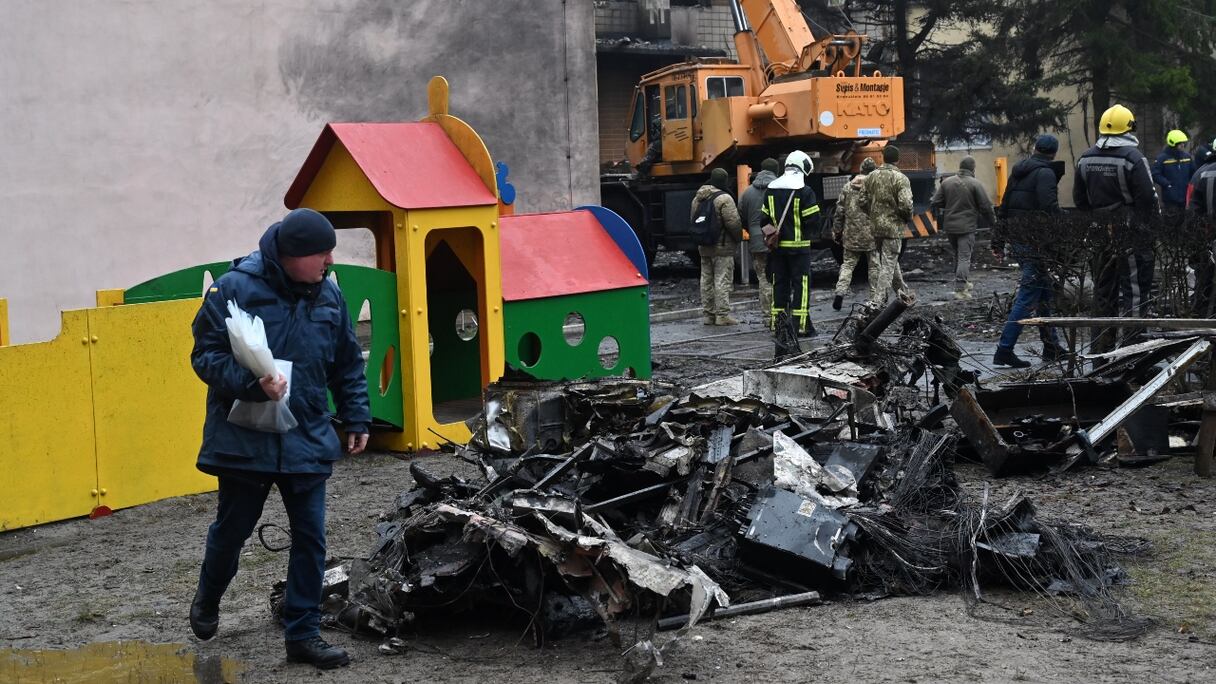 Des pompiers près du site où un hélicoptère s'est écrasé à côté d'un jardin d'enfants à Brovary, à l'extérieur de Kyiv, tuant 16 personnes, dont 2 enfants et le ministre ukrainien de l'Intérieur, le 18 janvier 2023.
