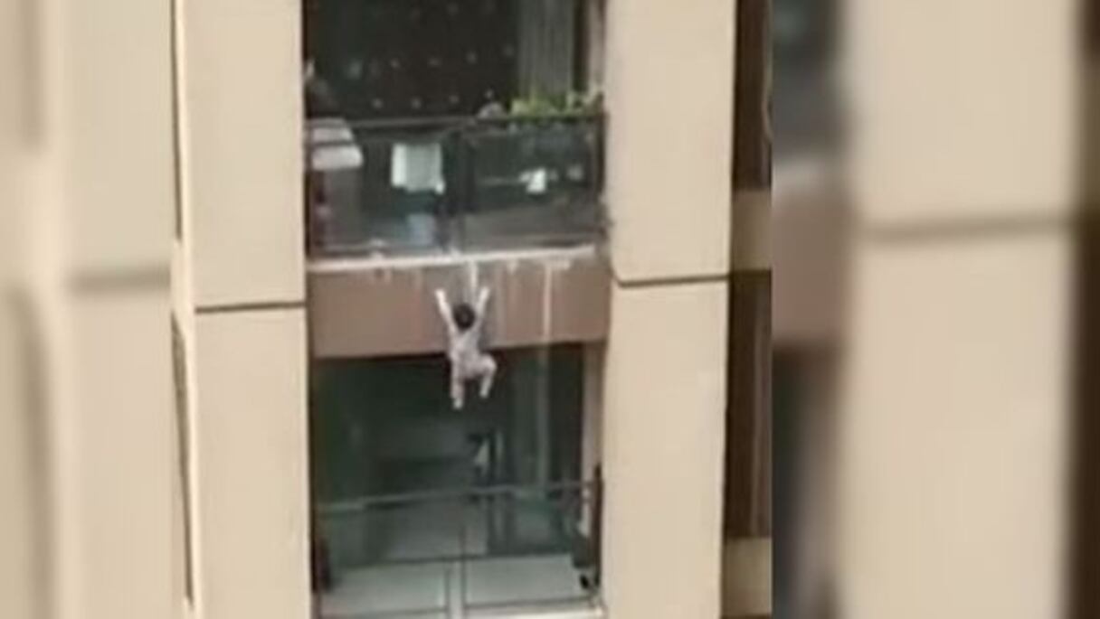 Un garçonnet suspendu au-dessus du vide.
