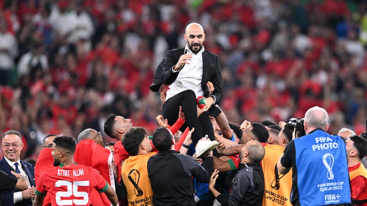 L'entraîneur marocain Walid Regragui est projeté dans les airs alors que les joueurs célèbrent la victoire du match de football de quart de finale de la Coupe du monde Qatar 2022 entre le Maroc et le Portugal au stade Al-Thumama de Doha le 10 décembre 2022.
