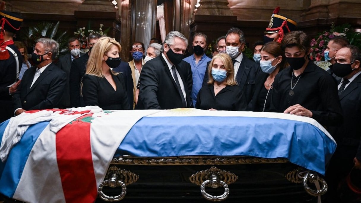 Le président argentin Alberto Fernandez (au centre), son épouse Fabiola Yanez (2e à gauche), et des membres de la famille de Carlos Menem se recueillent autour de son cercueil, lors d'une veillée funèbre au Congrès, à Buenos Aires le 14 février 2021. 
