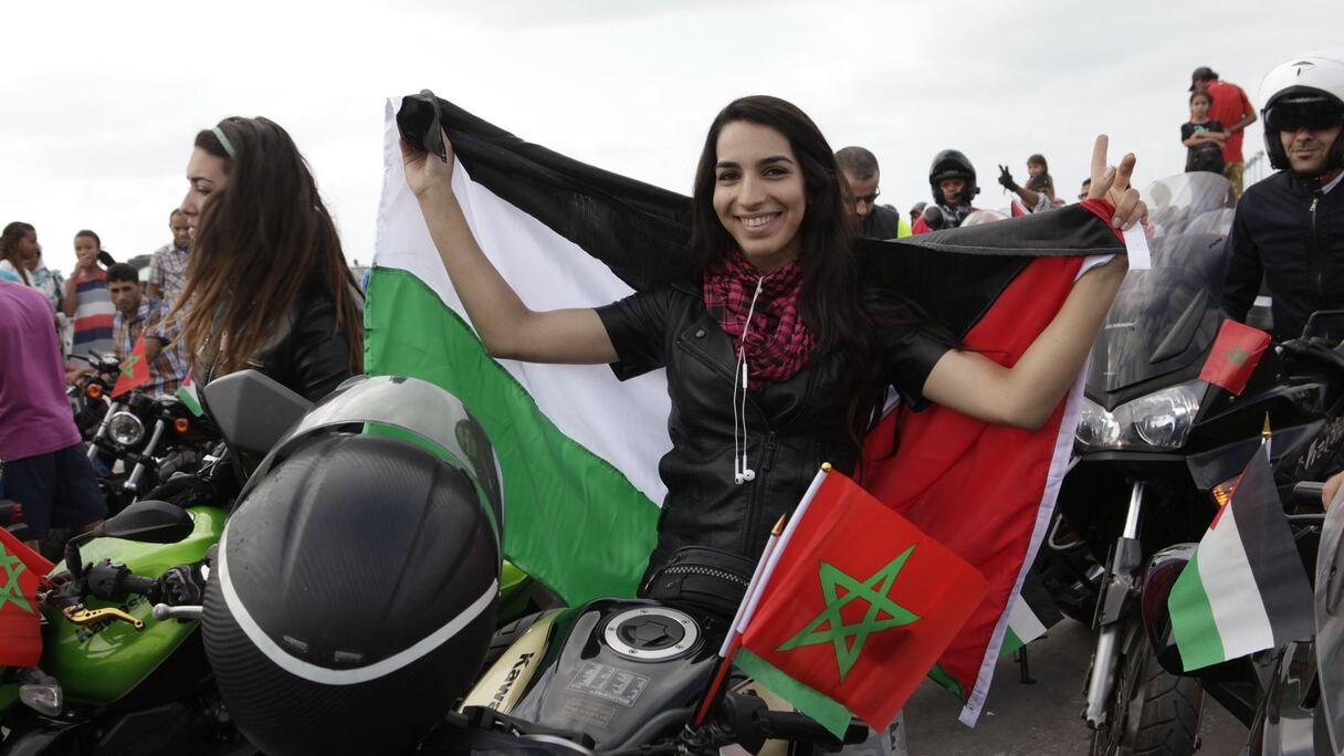Enroulés dans de larges drapeaux, les motards se préparent à rendre hommage au peuple de Gaza.
