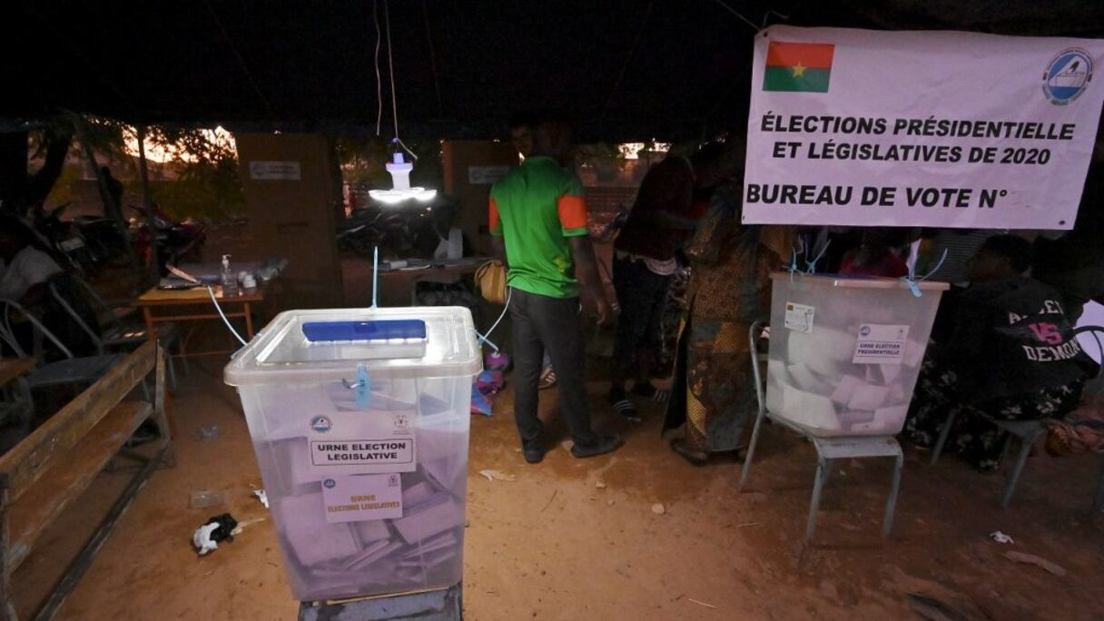 Les employés d'un bureau de vote à Ouagadougou se préparent à compter les bulletins de vote des scrutins législatif et présidentiel, dans la soirée du 22 novembre 2020 au Burkina Faso. 
