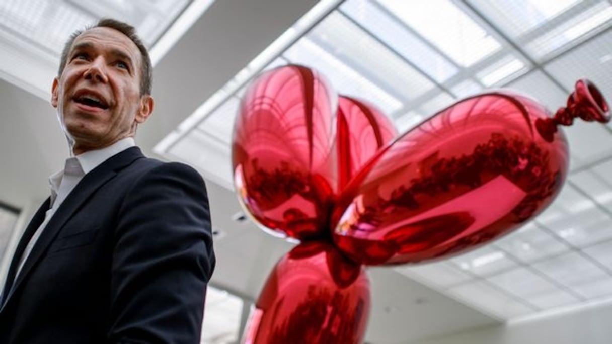 Jeff Koons aux côtés de son "Balloon dog". 
